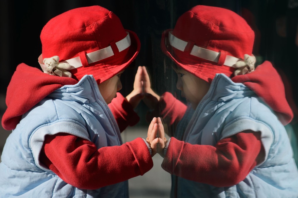A child looks at his reflection in a window in Beijing. China's Communist rulers announced an easing of the country's controversial one-child policy. Photo: AFP