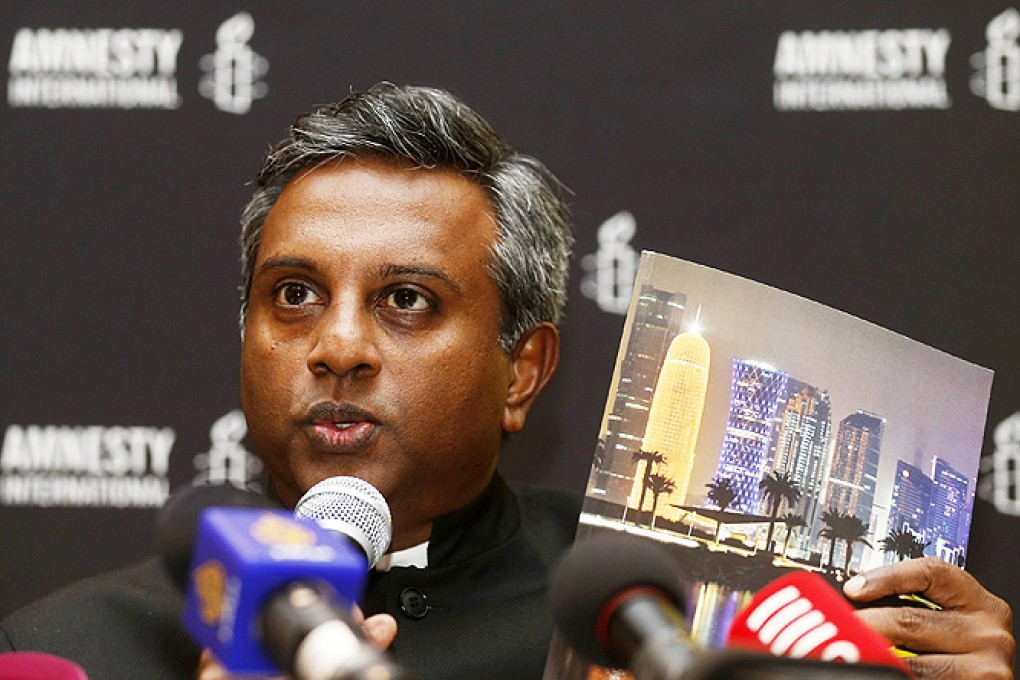 Amnesty International Secretary General Salil Shetty holds up a report titled 'The Dark Side of Migration: Spotlight on Qatar’s construction sector ahead of the World Cup', during a news conference in Doha. Photo: Reuters