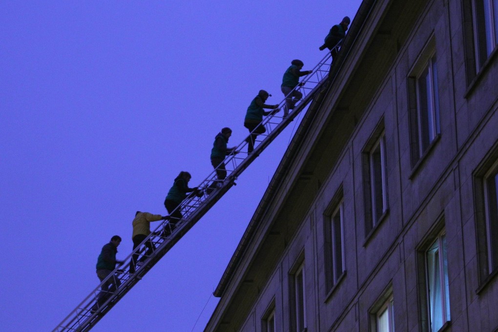 Polish Greenpeace activists climb on the roof of the Ministry of Economy in Warsaw. Photo: AFP