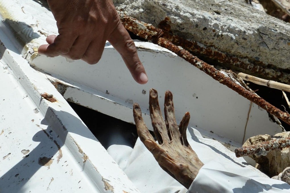 A calcified hand reaches from an unearthed grave. Photo: AFP