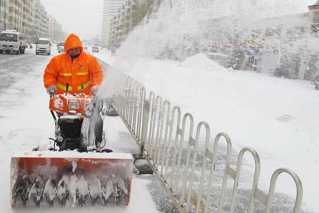 A sanitation worker clears the snow on a road in Harbin City, capital of northeast China's Heilongjiang province. Photo: Xinhua
