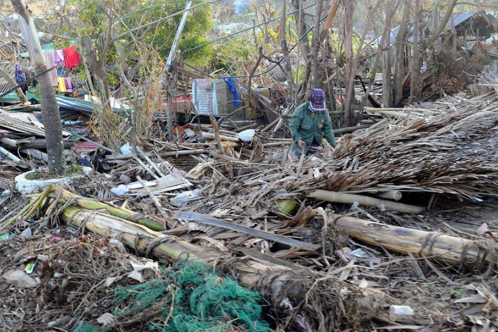 A woman salvages what is left of her belongings from her flattened house in an area devastated by Super Typhoon Haiyan. Photo: AFP