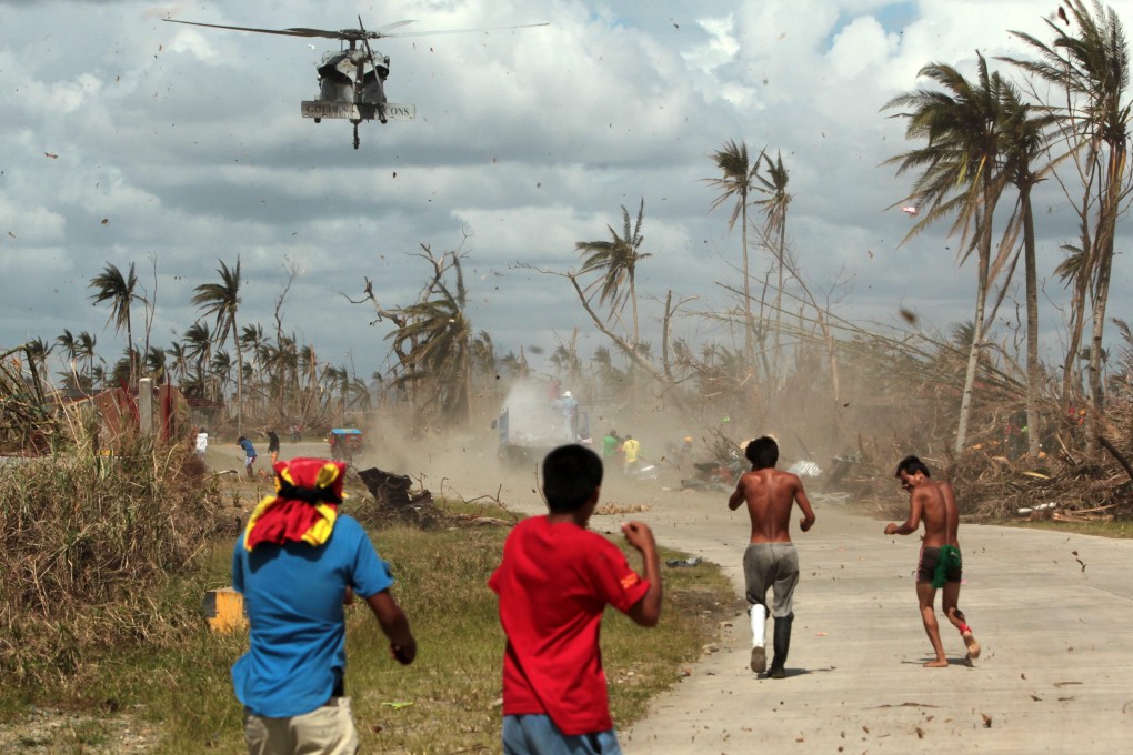 Filipino typhoon victims rush to get relief goods from a US Navy Sea Hawk helicopter in the typhoon devastated town of Palo, Leyte island province, Philippines. Photo: EPA