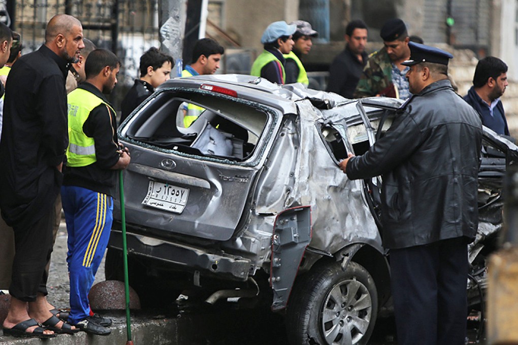 Iraqis inspect the site of a car bomb attack in the Karrada neighborhood in central Baghdad on Wednesday. Photo: AFP