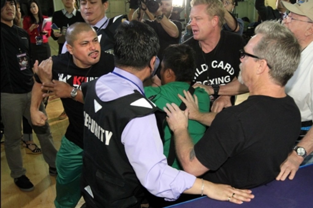Freddie Roach (right) in the melee between members of Brandon Rios and Manny Pacquiao's camps as security officers try to separate them. Photo: Chris Farina - Top Rank
