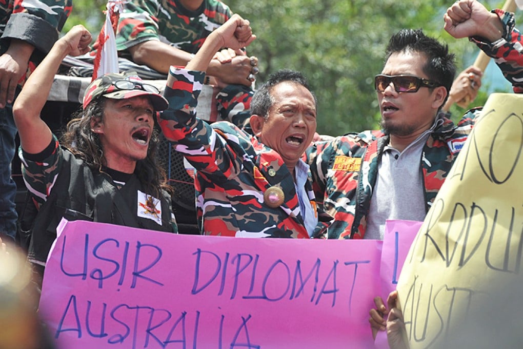 Anti-Australia protesters shout slogans while holding a placard, reading 'expel Australian diplomatic members', during a rally in front of the Australian embassy in Jakarta on Thursday. Photo: AFP