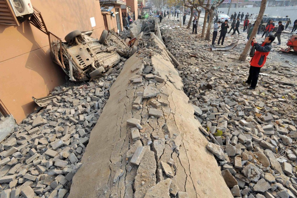 A wrecked car lies amid the debris of the oil pipeline explosion, which tore up streets in the Huangdao district of Qingdao. Photo: Reuters