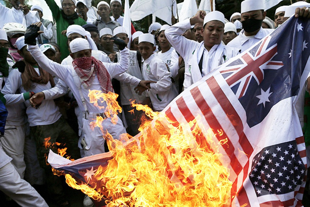 Indonesian activists burn a mock of Australian national flag during a protest against spying in front of the Australian embassy in Jakarta, Indonesia, on Friday. Photo: EPA