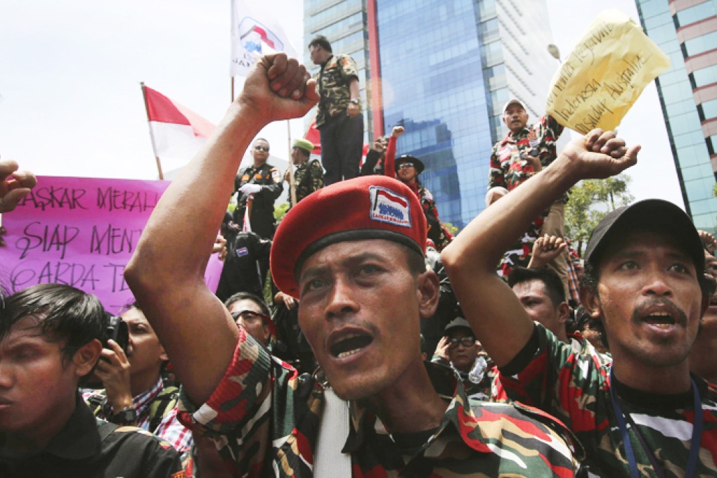 Protesters in military uniforms chant slogans outside the Australian Embassy in Jakarta yesterday as the spying row escalated. Photo: AP