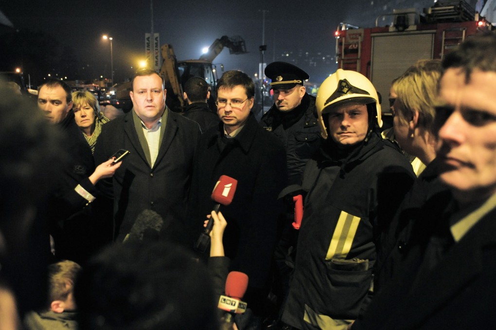 Latvian Prime Minister Valdis Dombrovskis (centre) outside the Maxima supermarket in Riga after its roof collapsed. Photo: EPA