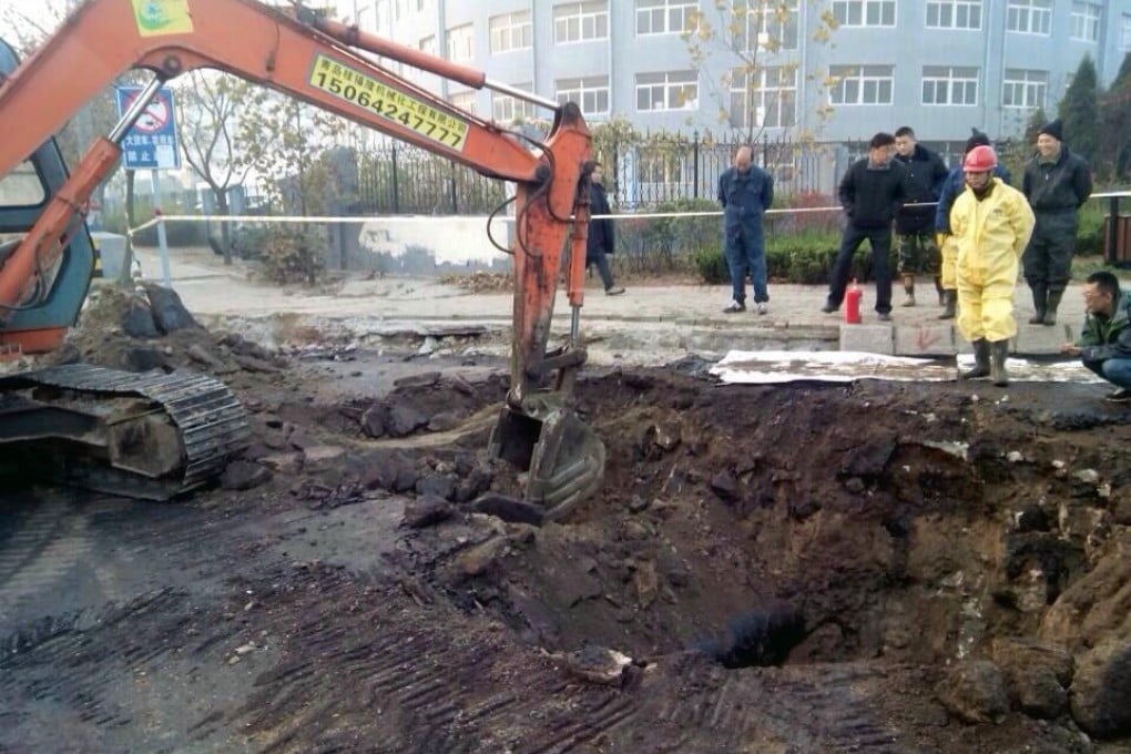 Sinopec safety officers inspect the site of the oil leak in Qingdao three hours before Friday's blast in a residential area. Photo: Xinhua