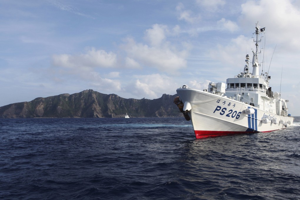 A Japan Coast Guard vessel sails in front of one of the disputed islands in the East China Sea. Photo: Reuters