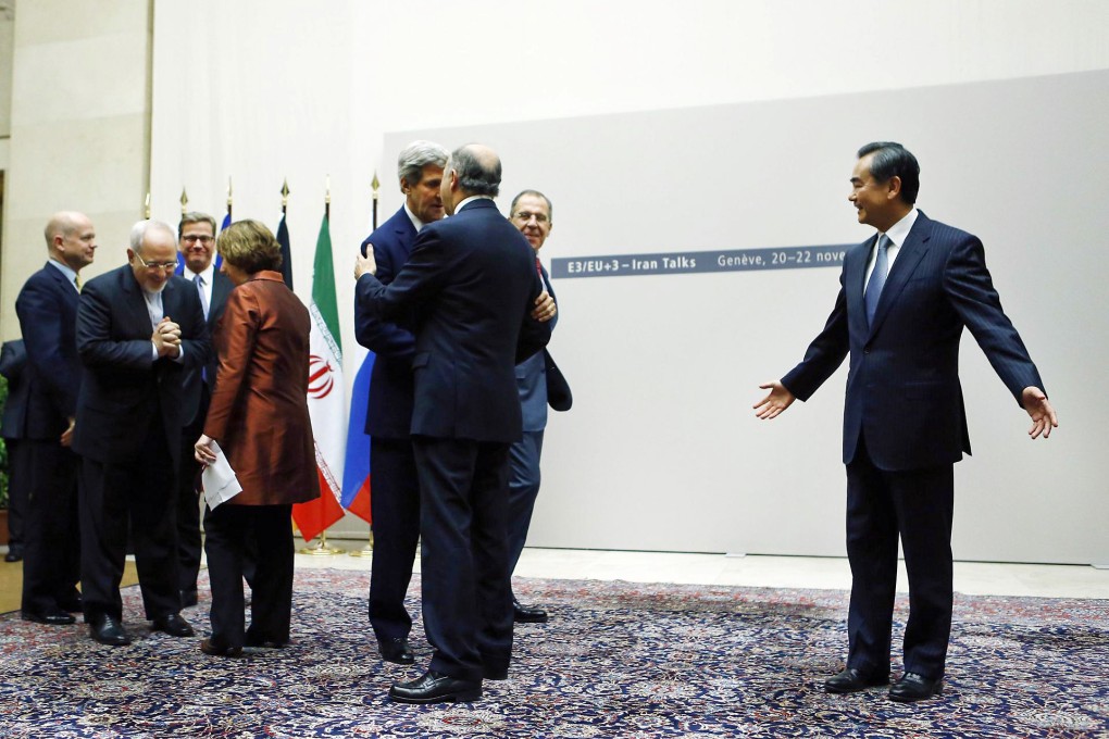 Foreign Minister Wang Yi (right) gestures to other diplomats as they embrace following the Iran nuclear talks in Geneva. Photo: Reuters