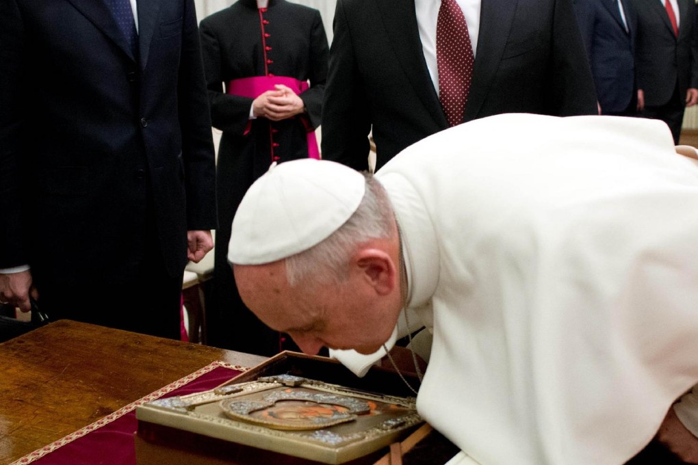 Pope Francis closely examines an icon of the Madonna gifted to him by Russian President Vladimir Putin at the Vatican. Photo: AFP
