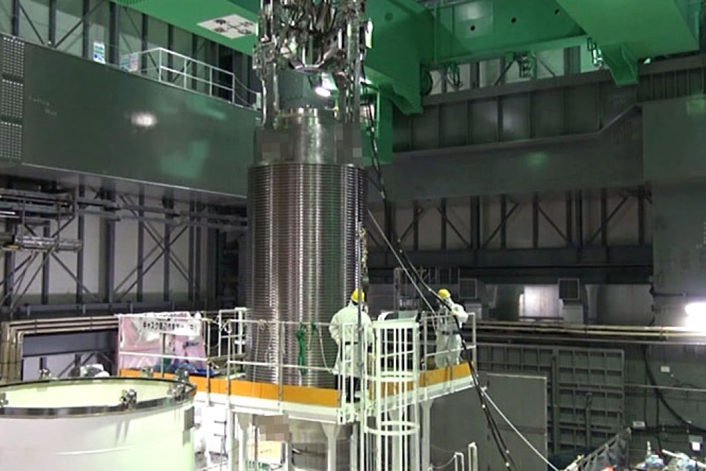 A cask of nuclear fuel rods is being transferred from a spent fuel pool of the unit four reactor building of TEPCO's Fukushima nuclear plant. Photo: AFP