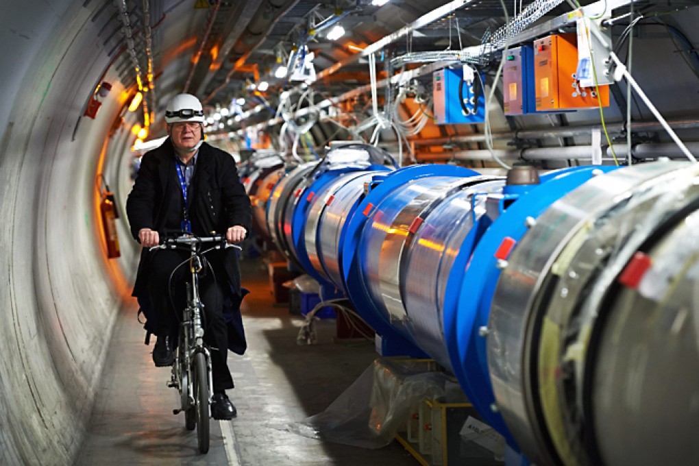 Polish scientist Andrzej Siemko riding a bike next to the Large Hadron Collider accelerator experiment at the European Organization for Nuclear Research CERN in Meyrin. Photo: EPA