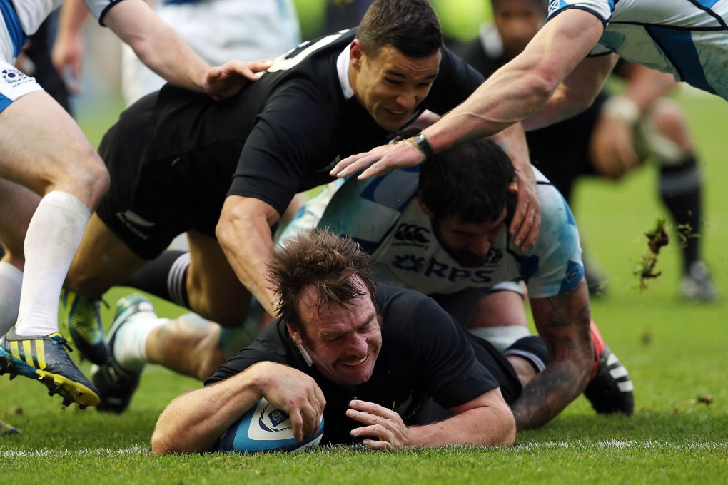 Andrew Hore scores for New Zealand in a clash with Scotland. He had 83 caps for the All Blacks. Photo: AFP