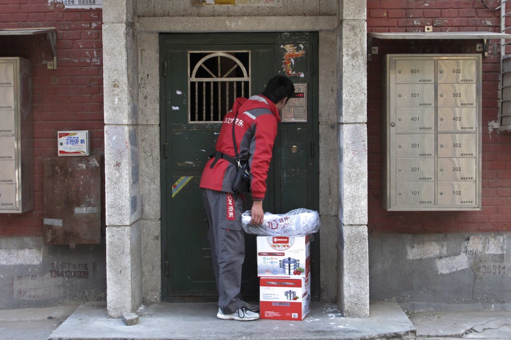 Jingdong's Cheng Honglei rings a doorbell as he makes a delivery. Jingdong prides itself on using its own couriers. Photo: Reuters