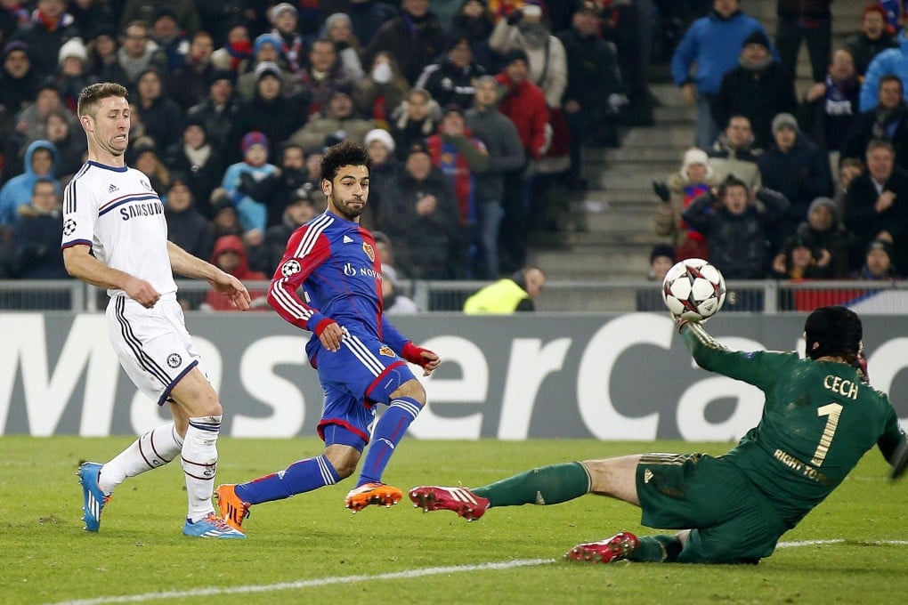 Basel’s Mohamed Salah (centre) lifts the ball over Chelsea goalkeeper Petr Cech to score the winning goal in their Champions League group E match in Basel. Photo: EPA