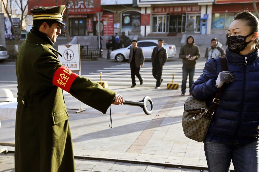 A security officer holds out a detector on a street in Urumqi, Xinjiang Uygur autonomous region. Photo: Reuters