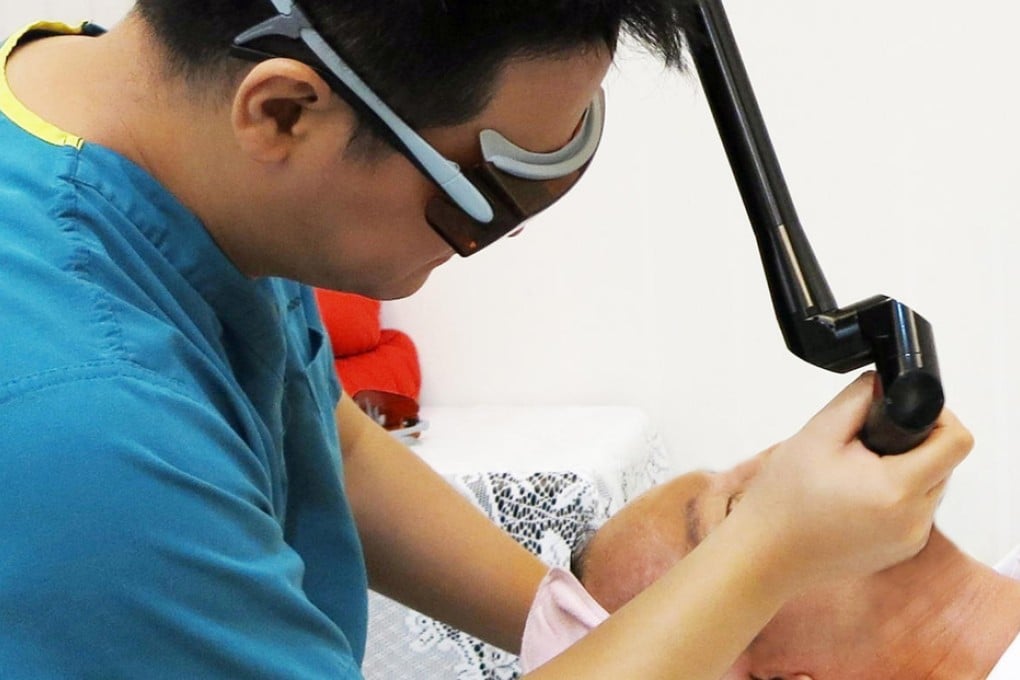 Dr Chu Chih-kai, head of the Beauty Plus clinic in Taipei, provides a laser cosmetic surgical treatment for a patient. Photo: SCMP