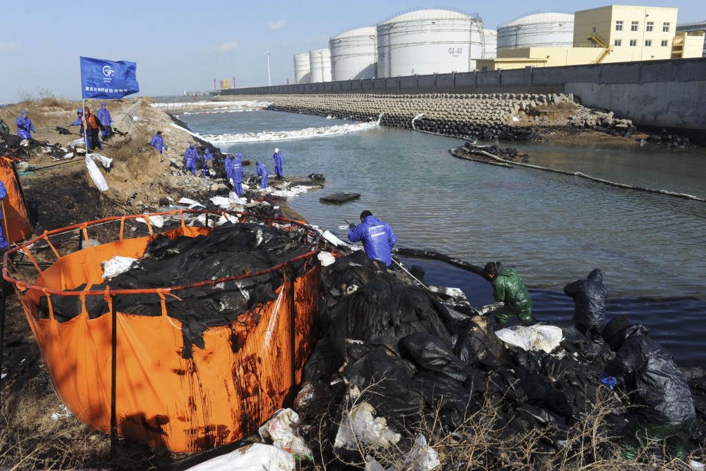 Sinopec workers clean up on Wednesday after the oil pipeline explosion in Qingdao last week. Photo: Reuters