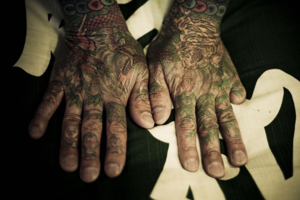 Tattooed hands missing a little finger. Photos: Anton Kusters