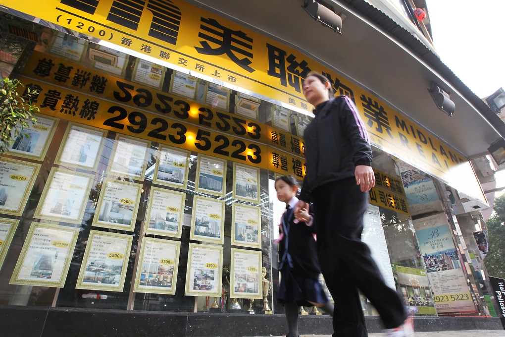 People walk pass a Midland Realty branch on Leighton Road. Photo: Edward Wong