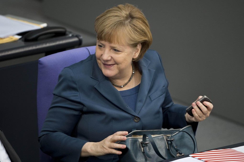 German Chancellor Angela Merkel takes her secure smartphone out of her bag in parliament. An enhanced version of the device is now on sale to the public. Photo: AFP