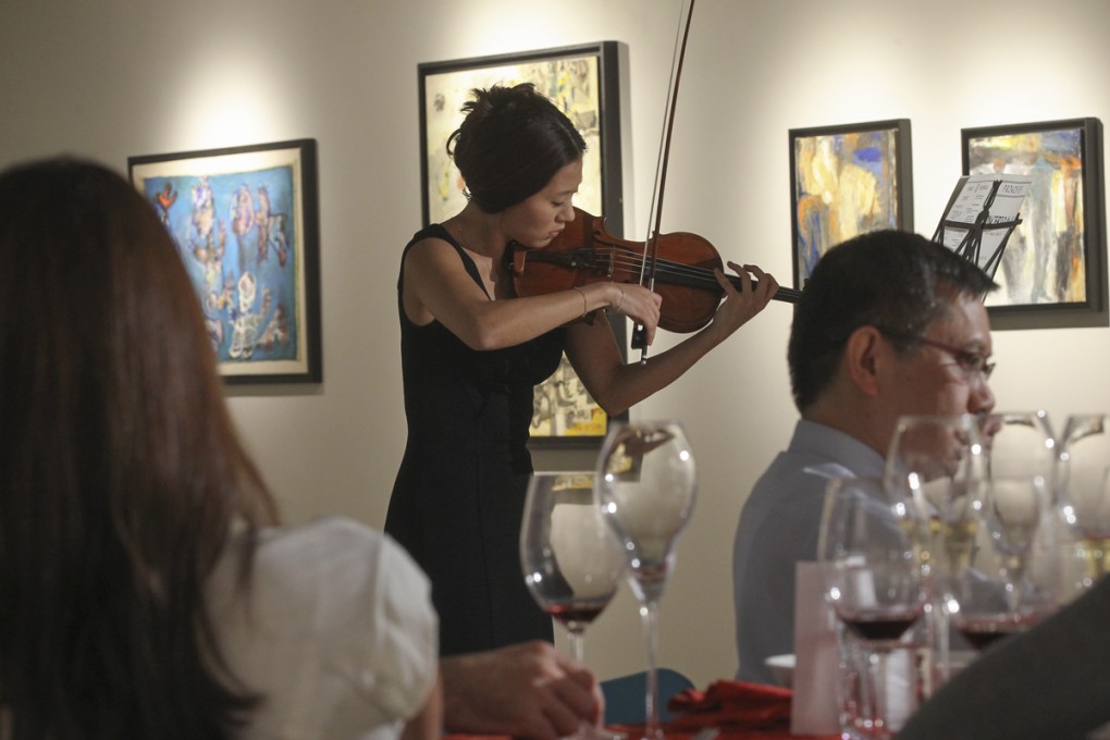 Violinist Erica Ye Byeol Lee plays one in a series of pieces she has composed to suit the food and wine being served to guests at a dinner exploring how music, art and food connect with people’s emotions. Photos: Edward Wong; AFP