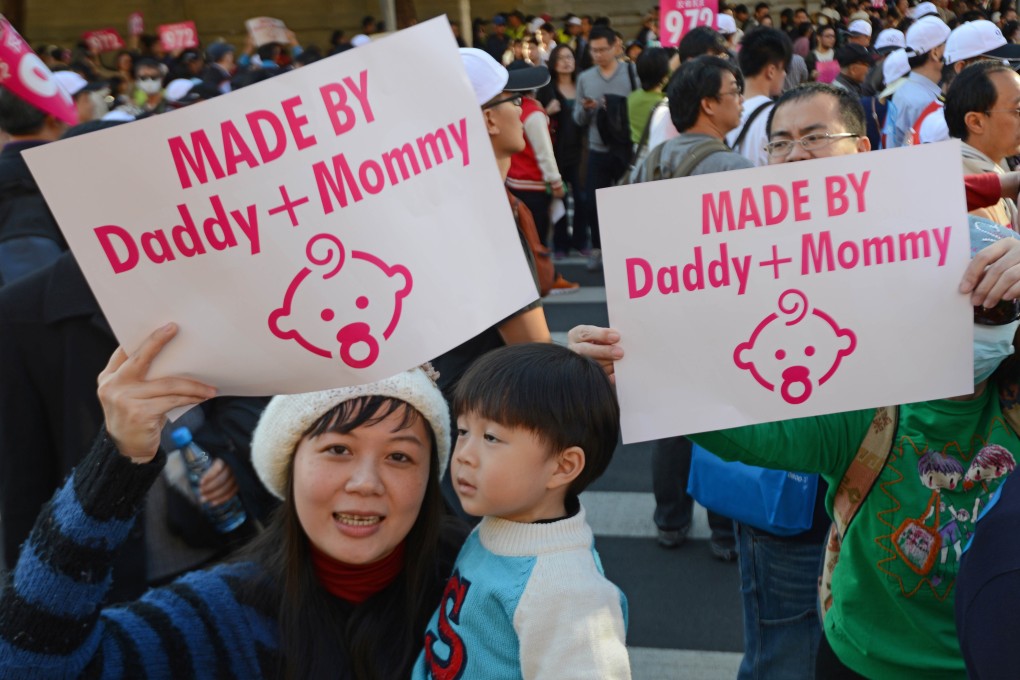 A mother displays a sign with her son during the anti-same sex marriage demonstration in Taipei on Saturday. Photo: AFP