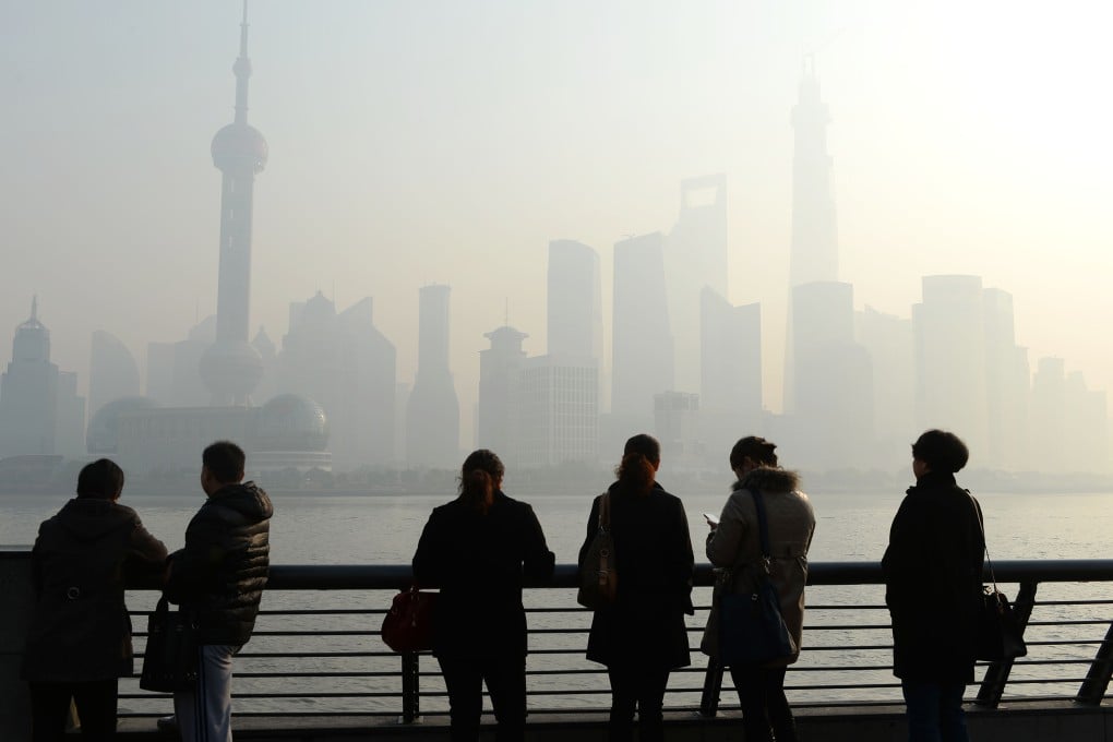 Visitors at the Bund, Shanghai, look at Lujiazhui on the other side of Huangpu River in heavy smog. Photo: China Foto Press
