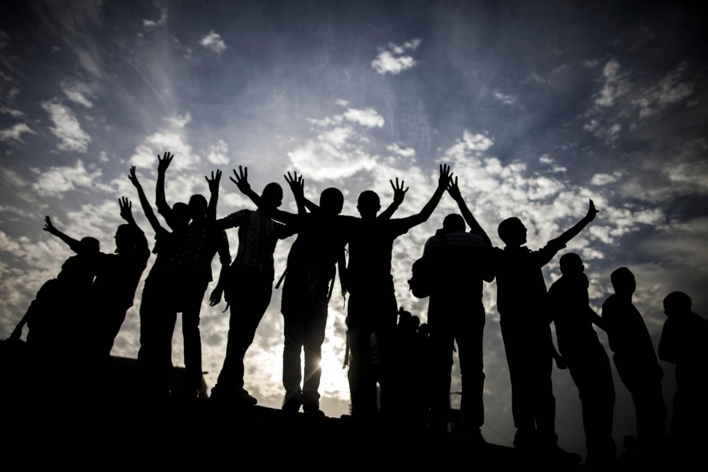 Cairo University students flash the four-finger sign protesting the government crackdown during a Tahrir Square protest. Photo: AFP