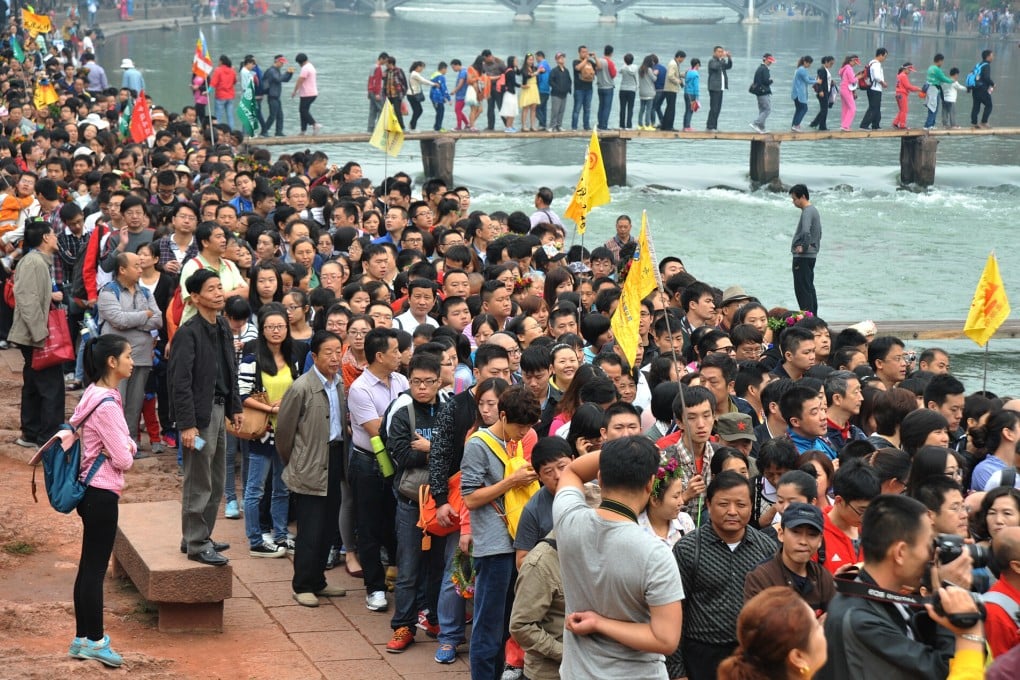 People queue to board tour boats to visit Fenghuang, central China's Hunan province, during Golden Week. Photo: Xinhua