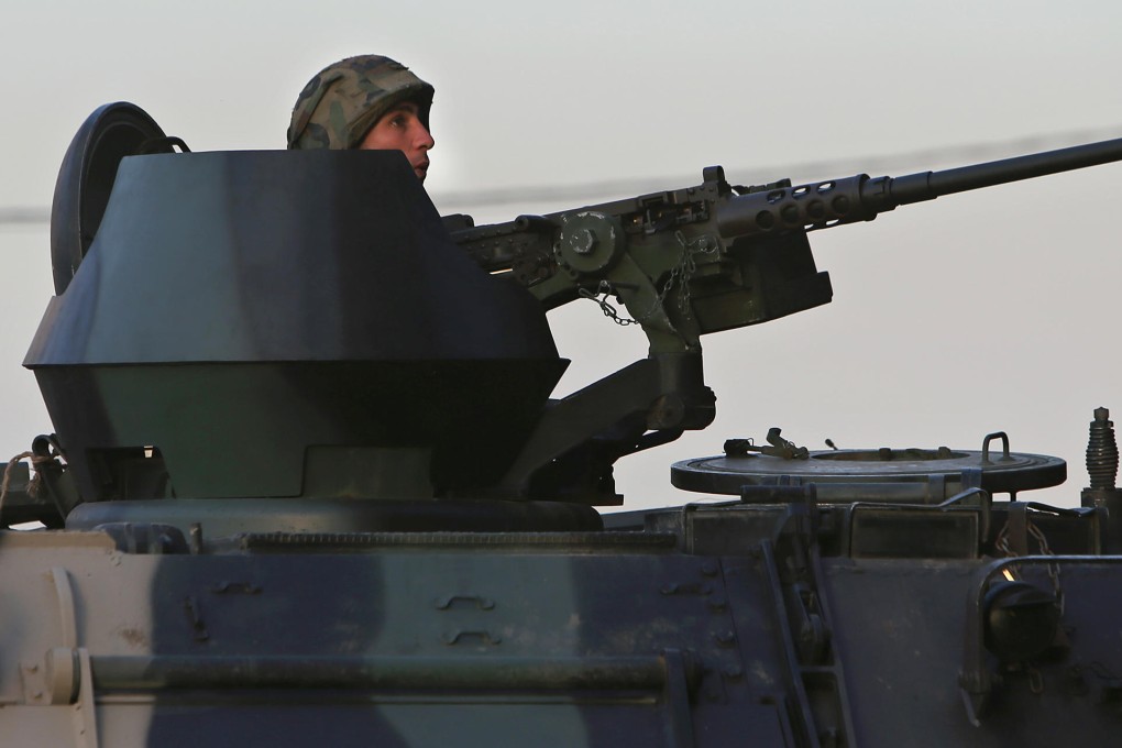 A Lebanese soldier sits behind his weapon in Tripoli, where escalating violence has ignited fears of a return to the chaos of the past. Photo: AP