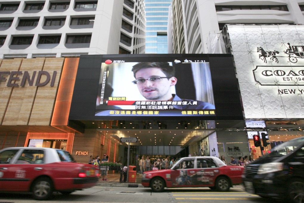 A TV screen in Central shows a report on former NSA contractor  Edward Snowden. Photo: AP