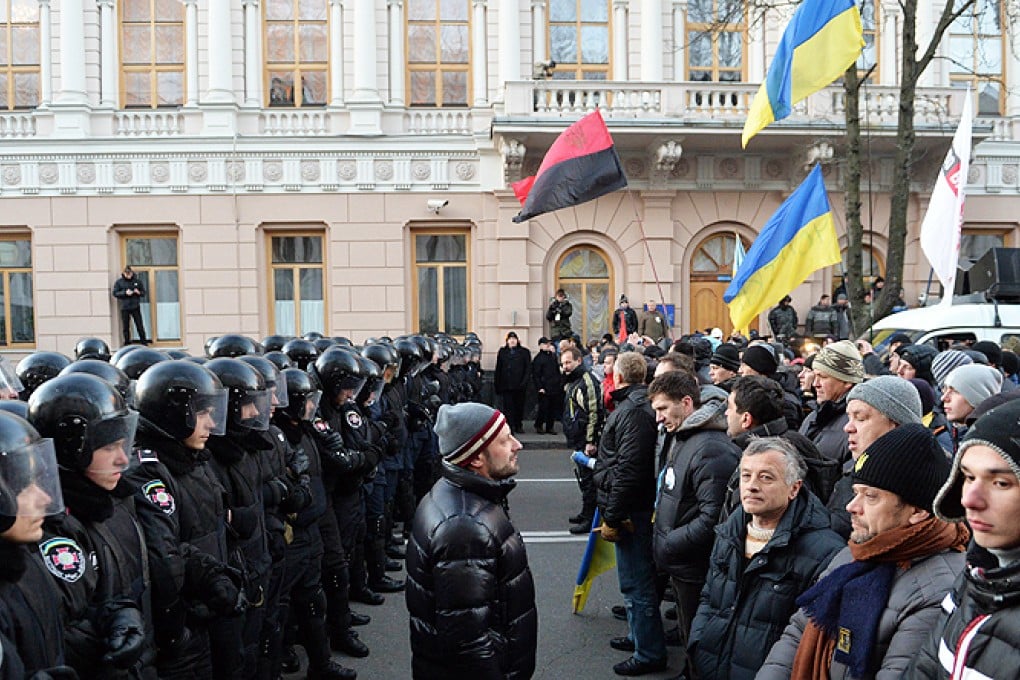 Protesters stand opposite riot policemen in front of the Ukrainian parliament in Kiev on Tuesday. Photo: AFP