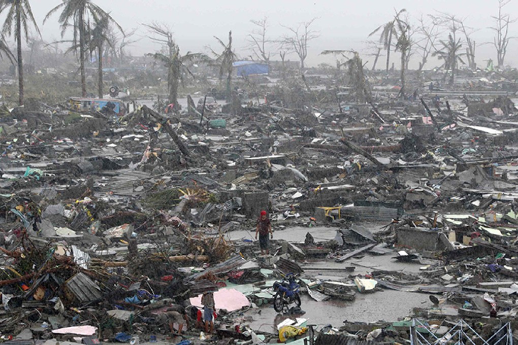Survivors stand among debris and ruins of houses destroyed after Super Typhoon Haiyan battered Tacloban. Photo: Reuters