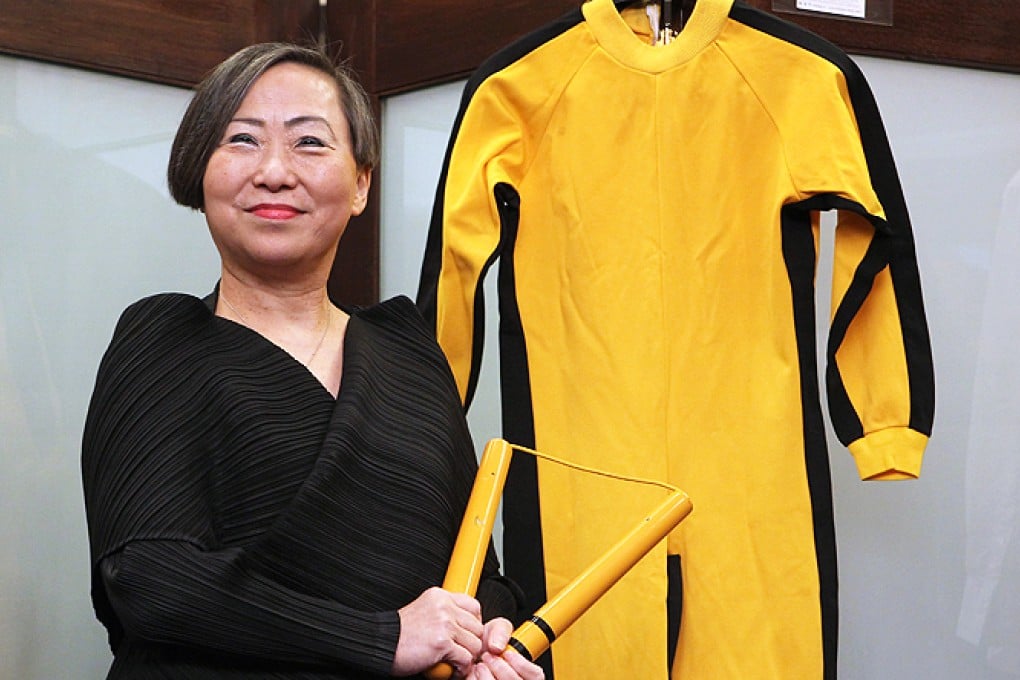 Anna Lee, Vice Chairman of Spink, shows Bruce Lee's nunchaku and jumpsuit on the media preview of Bruce Lee 40th anniversary collection auction in Wanchai. Photo: Edward Chan