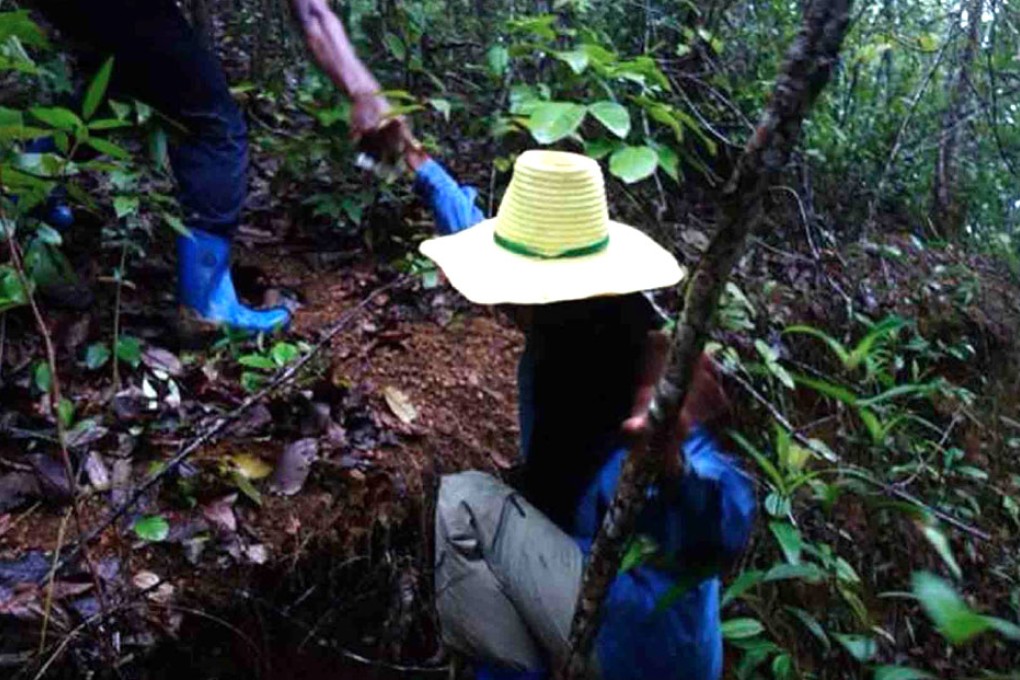 A special correspondent for the Post is assisted up a steep slope near one of the secret refugee camps in the jungles of southern Thailand. Photo: Phuketwan