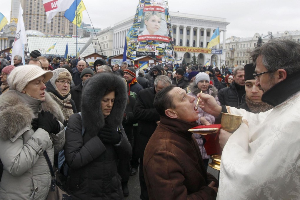 Protesters receive sacraments during a gathering organised by supporters of EU integration in central Kiev. Photo: Reuters