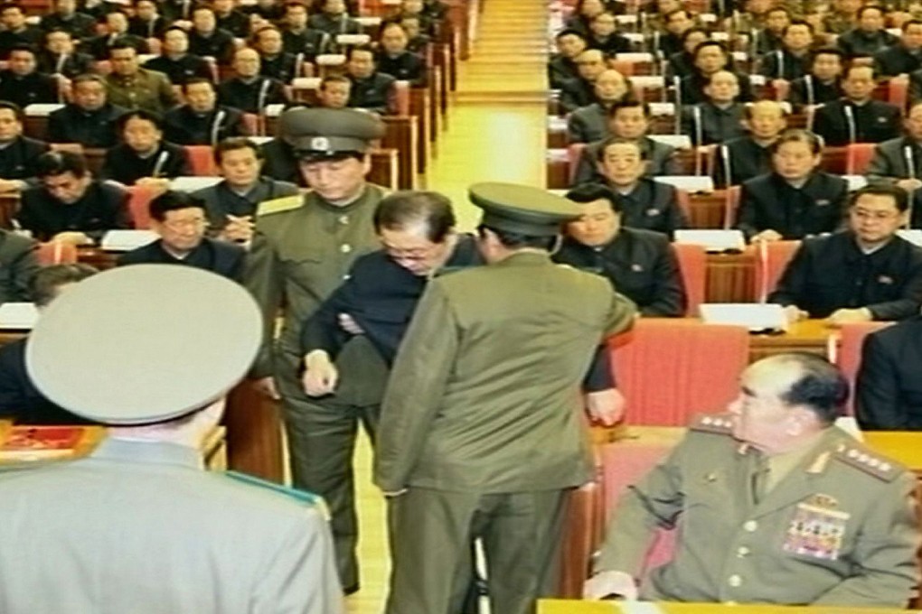 Kim Jong-un's uncle Jang Song-thaek is humiliatingly pulled from his chair by unformed officers at a meeting in Pyongyang. Photo: AFP