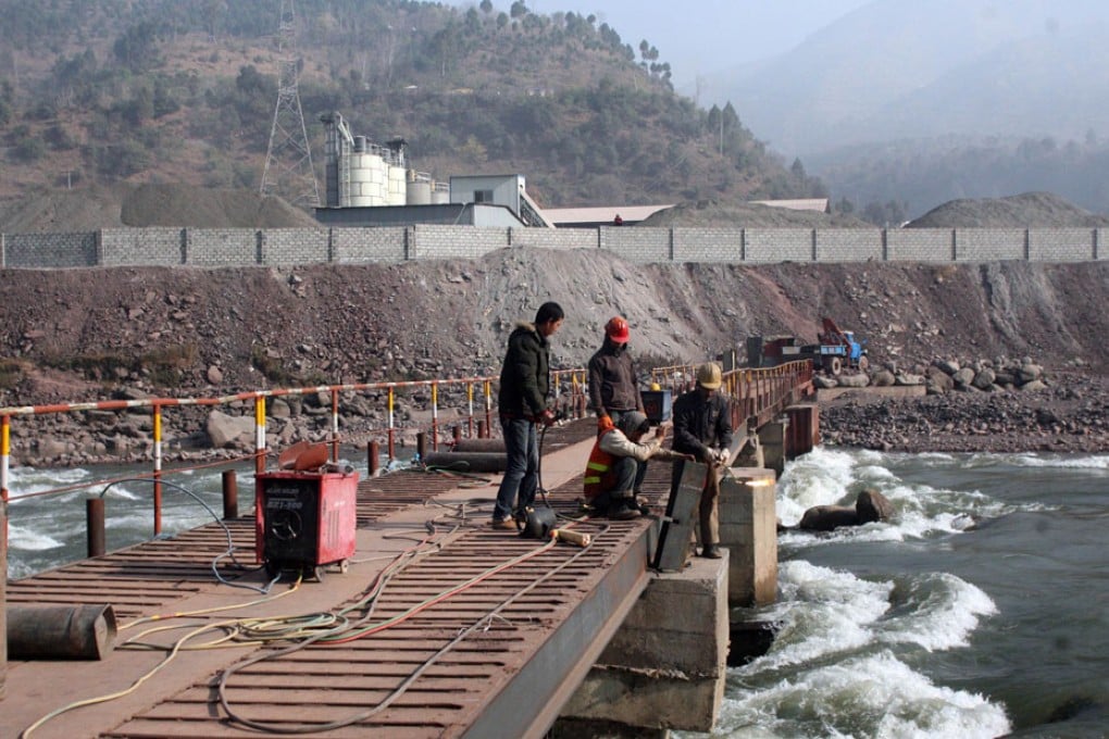 A Chinese engineer (left) supervises workers building a bridge over a river in Ghari Dopatta, some 22 kms from Muzaffarabad, the capital of Pakistani-administered Kashmir. Photo: AFP