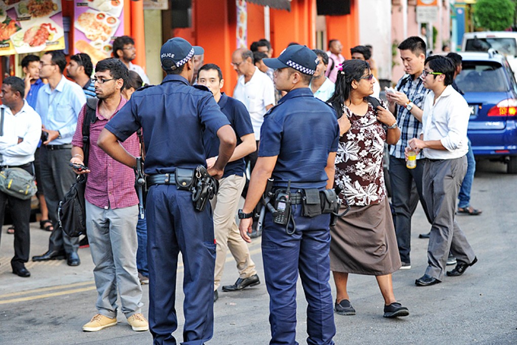 Policemen stand on the street in Little India on Monday, following a riot the day before by South Asian workers in the worst outbreak of violence in more than 40 years in the tightly controlled city-state. Photo: AFP