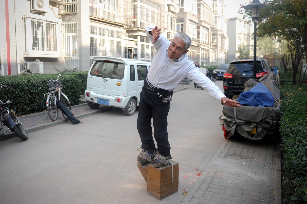 For the past seven years, Zhang Fuxing has walked in iron shoes, in what he views as a healthy habit. Here, he is taking a stroll in a residential district in Tangshan, Hebei province. Photo: AFP
