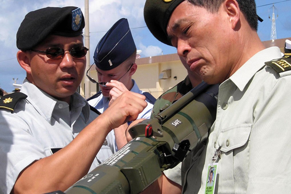 A PLA delegation member inspects US weaponry in Guam. Photo: Xinhua