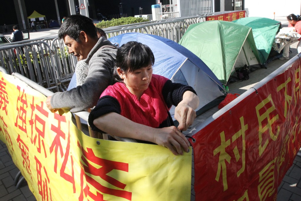 Villagers of Tai Long Sai Wan in Sai Kung protest outside government headquarters to oppose the government's plan to incorporated the area into a surrounding country park.