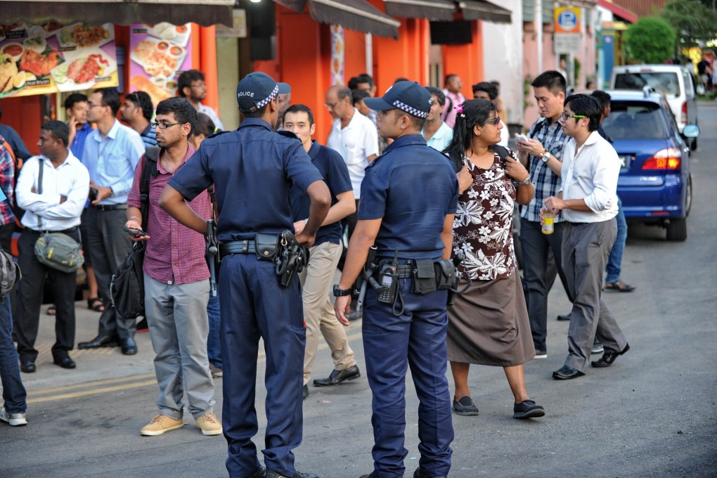 Policemen stand on the street in Little India, following a riot by South Asian workers in the worst outbreak of violence in more than 40 years in the tightly controlled city-state. Photo: AFP