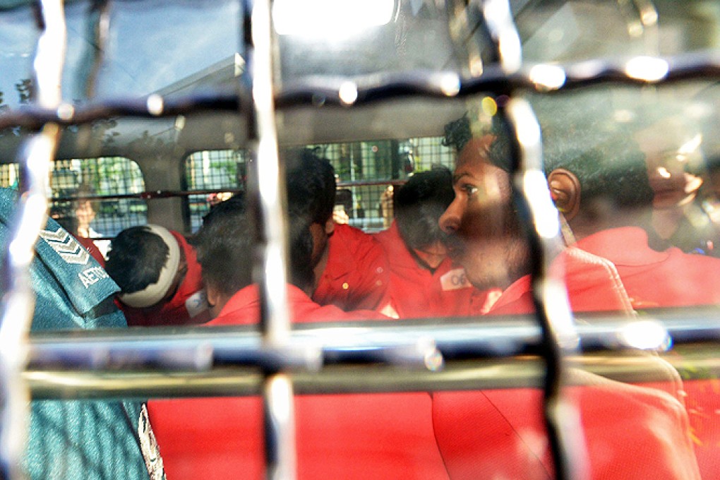 A group of Indian nationals, who allegedly took part in Singapore's first riot for over 40 years, arrive in a police van at the Subordinate courts to be charged. Photo: AFP