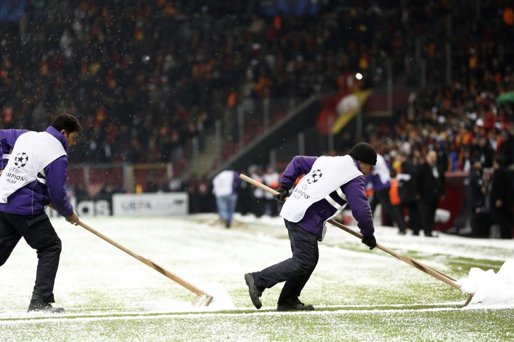 Workers clean the pitch from hail and snow during the Uefa Champions League group B match between Galatasaray and Juventus in Istanbul. The match was abandoned due to heavy snowfall. Photo: EPA